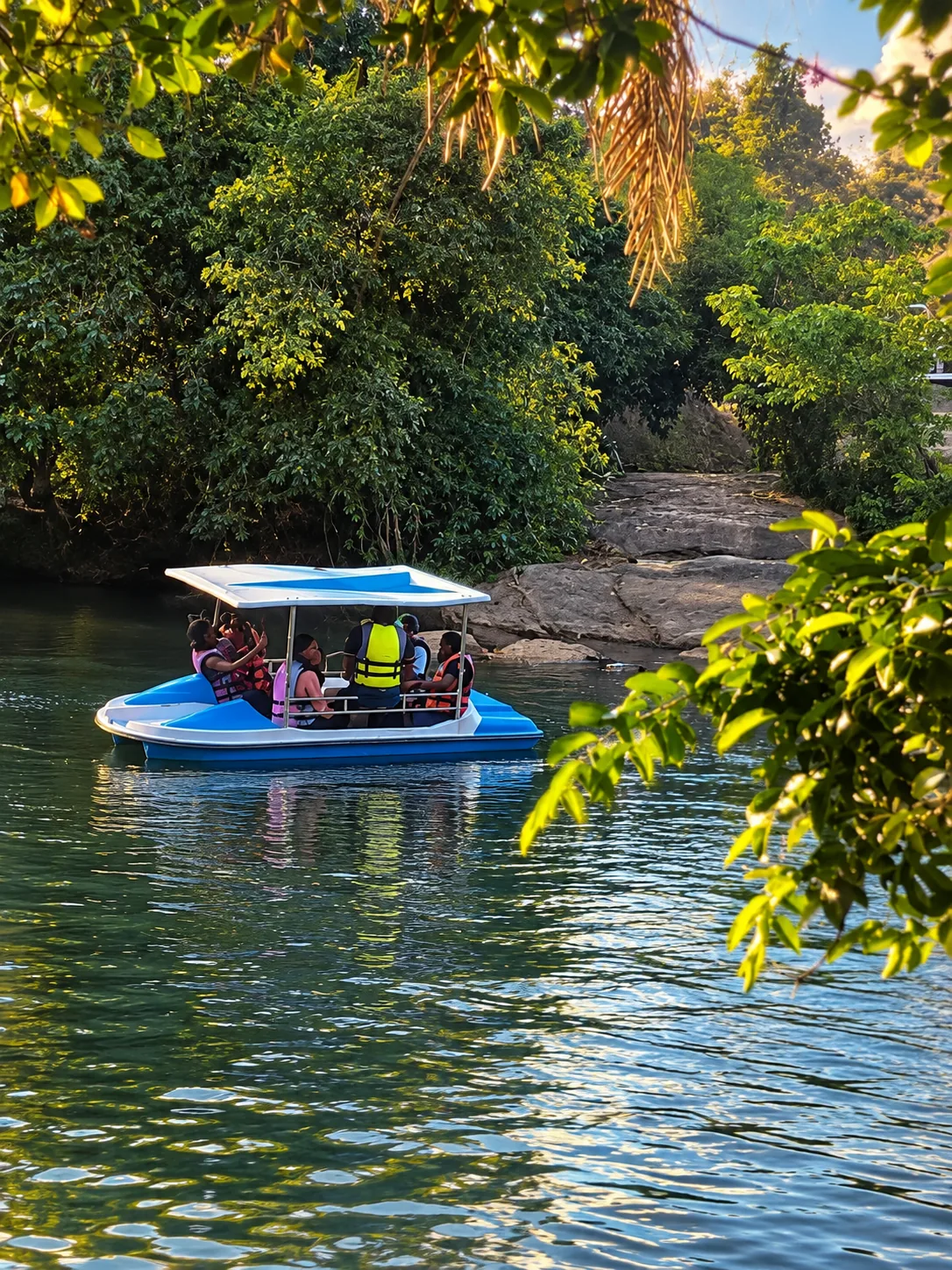 Visitors in a covered blue boat on the river